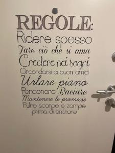 a sign on a bathroom wall with writing on it at La Casa di Mimmi in Mantova