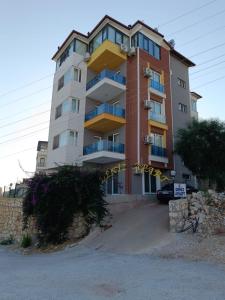 a tall building with a sign in front of it at Deniz Apart in Demre