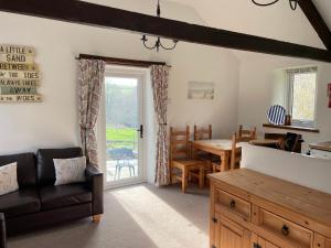 un salon avec un canapé et une table dans l'établissement Dozmary Cottage, à Launceston