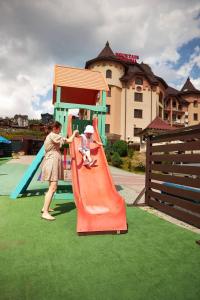 een vrouw die met een kind speelt op een glijbaan bij Mountain Krystal in Boekovel