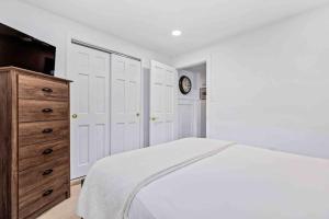 a bedroom with a bed and a dresser and a clock at Riverview Retreat On Warehouse Creek in Edgewater