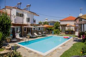 a swimming pool in the backyard of a house at Alexander Aqua Oasis - Poolside Garden Getaway in Evkarpía