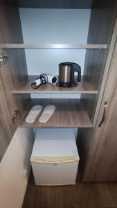a cupboard with a pot sitting on a shelf at BATUM Hotel in Batumi