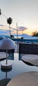 une terrasse avec une table et des chaises et un coucher de soleil dans l'établissement ΠΑΝΩ ΣΤΟ ΚΥΜΑ, à Salamine