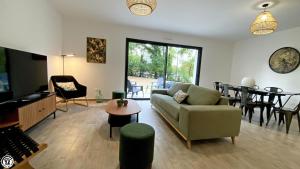 ein Wohnzimmer mit einem Sofa und einem Tisch in der Unterkunft Breakislebed Chambres ou suites dans maison in Isle