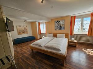 a bedroom with a bed and a flat screen tv at Hotel Taverne zur Linde in Bischofszell