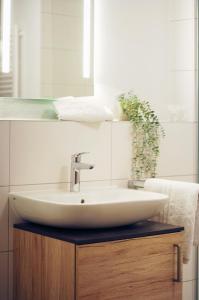 a bathroom with a sink and a mirror at Hotel am Wittelsbacher Markt by greenpartment in Langquaid +6 photos