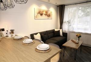 ein Wohnzimmer mit einem Tisch und einem Sofa in der Unterkunft Gape Apartment in Limbaži