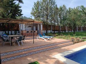 a patio with a table and chairs next to a pool at casa sierrecilla in Fuente de Piedra