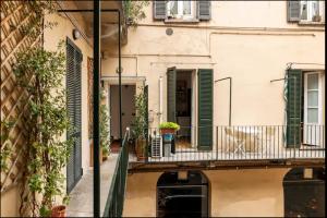 Un balcón de apartamento con persianas verdes en un edificio. en Piazza Volta Apartment, en Como