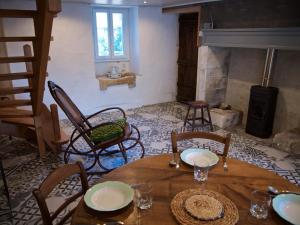 a room with a table and chairs and a fireplace at Le soleil couchant en Périgord in La Gonterie-Boulouneix