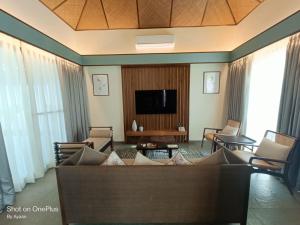 a living room with a couch and a tv at The Golkonda Resort and Spa in Hyderabad