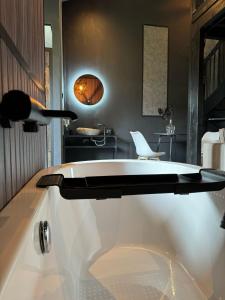 een bad in een kamer met een tafel en een stoel bij Luxury Loft in Velddriel