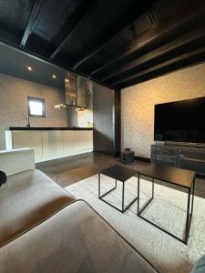 sala de estar con sofá y TV de pantalla plana en Luxury Loft, en Velddriel