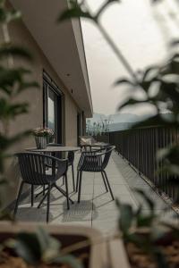a patio with tables and chairs on a balcony at Belia Lofts - ADULTS ONLY - Apartments in Appiano sulla Strada del Vino