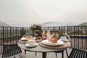 een tafel met borden eten op een balkon bij Belia Lofts - ADULTS ONLY in Appiano sulla Strada del Vino