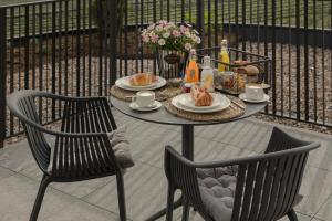 a table with two chairs and a table with food on it at Belia Lofts - ADULTS ONLY - Apartments in Appiano sulla Strada del Vino