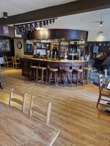a bar in a restaurant with wooden floors and bar stools at Ring O Bells in Chagford