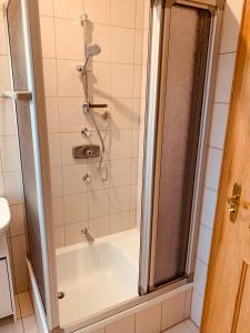La salle de bains est pourvue d'une baignoire et d'une douche. dans l'établissement Adlerhorst, 4 Schlafzimmer, Blick in die Alpen, Parkplatz, à Thyrnau