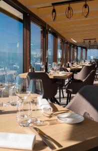 un ristorante con tavoli e sedie con bicchieri da vino di Baron Tavernier Hotel Restaurant & SPA a Chexbres