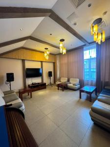 a living room with couches and a flat screen tv at Hotel Alma-Ata in Borovoye