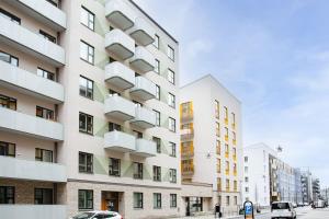 un edificio blanco alto con balcones en una calle de la ciudad en Modern Stylish Apartment With Balcony In Stockholm, en Järfälla