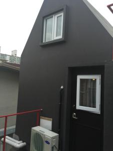 a black house with a door and a window at I House Chinchin in Seoul