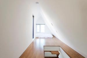 a white room with a bench and a bed at I House Chinchin in Seoul