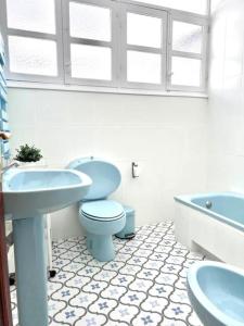 y baño con aseo azul y lavamanos. en VélezVida Serna, en Vélez Rubio