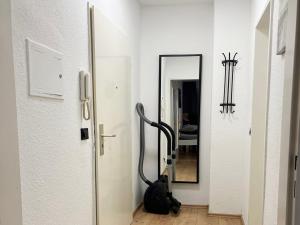 pasillo con espejo y bolsa en el suelo en Low Budget Apartment Cologne, en Colonia
