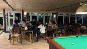 a group of people sitting in a restaurant with a pool table at Country View Camping in Bratton