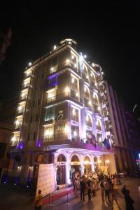 a large building with people standing in front of it at night at Q Hotel in Beirut