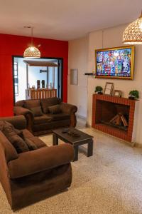 a living room with two couches and a flat screen tv at Renty Paraguay in Asuncion