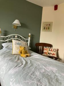 a teddy bear sitting on top of a bed at Brandreth Barn in Burscough