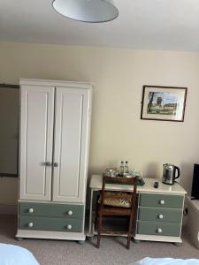 a bedroom with a desk and a cabinet and a table at Brandreth Barn in Burscough