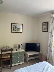 a bedroom with a bed and a tv and a dresser at Brandreth Barn in Burscough