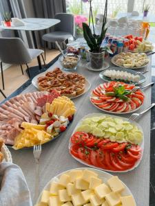un tavolo con molti piatti di cibo sopra di Cavaldi Aparthotel a Dziwnów
