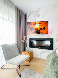 a living room with a chair and a tv at Cavaldi Aparthotel in Dziwnów