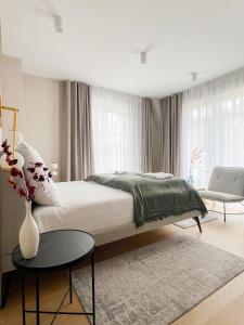 a bedroom with a large bed and a vase with flowers at Cavaldi Aparthotel in Dziwnów