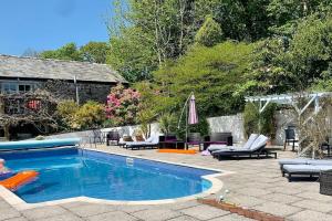 a backyard with a swimming pool with chairs and a patio at Siblyback Cottage in Launceston