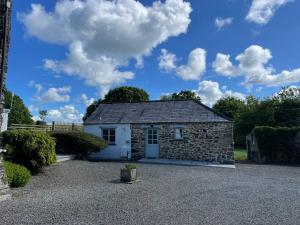 a small stone house with a gravel driveway at Siblyback Cottage in Launceston