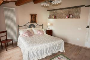 a bedroom with a bed with pink pillows on it at Dimora nel Castello di Loretello in Loretello
