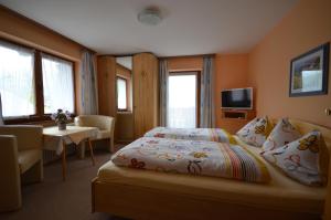 una habitación de hotel con una cama y una mesa en Gästehaus Friedl, en Kirchberg in Tirol