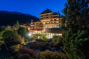 een groot gebouw 's nachts met verlichting bij Hotel Vereina in Klosters