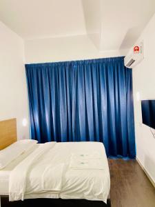 a bedroom with two beds and a blue curtain at BIG TREE HOTEL in Temerloh