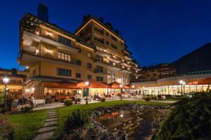 een hotel met tafels en stoelen voor een gebouw bij Hotel Vereina in Klosters