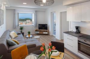 uma cozinha e sala de estar com um sofá e uma mesa em Bella Figura II em Makarska