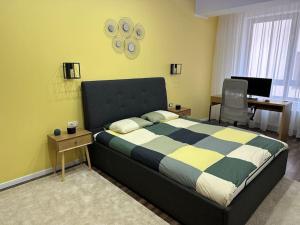 a bedroom with a bed and a desk with a computer at Stylish newly renovated apt feels like second home in Bucharest