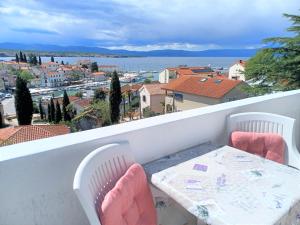 uma mesa e cadeiras numa varanda com vista em Guesthouse Cecilia em Malinska