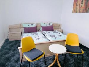 um pequeno quarto com uma cama com três cadeiras em Ferienwohnung zur Schobse em Ilmenau